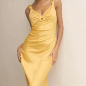 ADOORE Nîmes Klänning 34 - Snygg gul klänning från ADOORE med smala axelband och en elegant v-ringning. Klänningen har en figurnära passform och är perfekt för sommarens festligheter. Materialet ger en lyxig känsla och den långa längden ger en sofistikerad look.