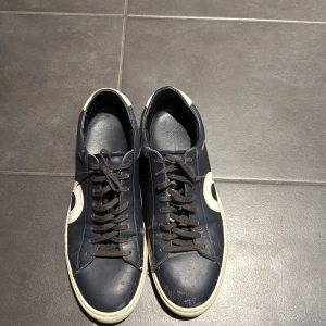 Blå sneakers från Oliver Cabell - Snygga blå sneakers från Oliver Cabell med vita detaljer och snörning. Skorna har en rund tå och en vit sula som ger en stilren look. Perfekta för en avslappnad stil.