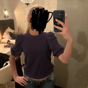 Lila tröja med puffärmar - Säljer en snygg lila tröja med puffärmar och ribbade muddar. Perfekt för en trendig look. Tröjan har en rund halsringning och är i ett mjukt material.