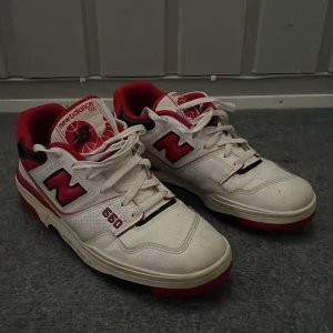 New Balance 550 - Säljer ett par New Balance 550, röd, svart och vit, använda sparsamt det ända skadan är en spricka på vänster skon men annars sparsamt använda!
