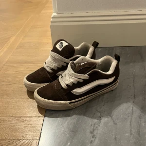 Bruna sneakers från Vans - Snygga bruna sneakers från Vans i mocka med vita detaljer och snörning. Perfekta för en avslappnad stil. Det går att byta skosnören ifall man vill ha de vitare men har inga hemma! Väldigt sköna och fin kvalitet! Köpare står för frakt eller mötas på Östermalm!❤️
