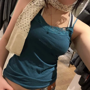 Mörkblå linnetopp med spetsdetaljer - Snygg mörkblå linnetopp med spetsdetaljer vid halsringningen. Skön passform med justerbara axelband! passar xs-m