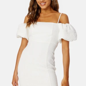 Vit klänning med puffärmar från bubbelroom  - Säljer en elegant vit klänning från bubbleroom med puffärmar och offshoulder-design. Klänningen har en strukturerad yta och smala axelband för en stilren look. Perfekt för speciella tillfällen! 🌟Helt slutsåld online! Köpt för 879 🎀
