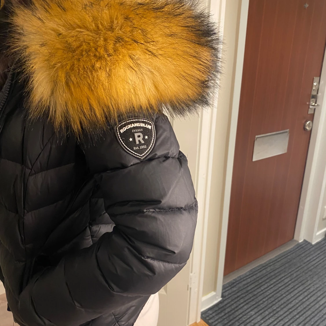 Svart dunjacka med pälsdetalj från Rockandblue