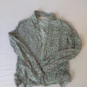 Blommig topp 💐 - Gullig blommig långärmad med knappar :)  Finns en liten ficka uppe till höger! 