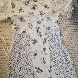 Somrig blommig klänning - Helt ny somrig klänning som tyvärr aldrig kommer till använda. Passar ungefär som en large. Lappar sitter fortfarande kvar. Köptes på Asos. Supersnygg till sommaren! 