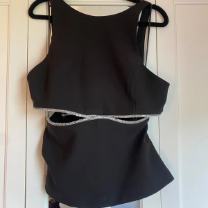 Topp med silverdetaljer  - Fin topp med silverdetaljer och öppen rygg