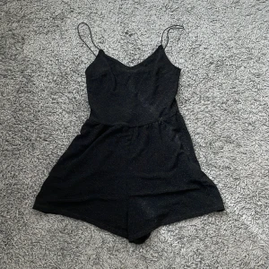 Jumpsuit  - Glittrig jumpsuit från H&M, använd en gång 