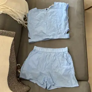 Säljer ett superfräscht set med ljusblåa shorts och matchande topp. Shortsen har en elastisk midja och är riktigt bekväma, perfekta för varma sommardagar. Toppen är croppad och har en liten slits i ryggen för extra stilpoäng. Setet är gjort i ett mjukt och skönt material, troligtvis bomull. Perfekt för en avslappnad dag på stranden eller en somrig utflykt! 🌞