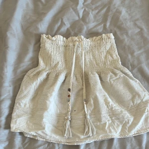 Vit bohemisk tubtopp med knytband - Säljer en superfin vit bohemisk kjol med smockdetaljer och knytband framtill. Kjolen har en bekväm passform och är från zara i storlek xs 💓