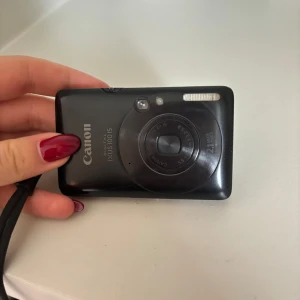 Canon ixus 100 is - Säljer en Canon ixus 100 is digitalkamera. Kameran är svart och har en liten skärm på baksidan. Den har en rem och en knapp för att ta bilder. Kameran har en inbyggd blixt och en zoomfunktion. Blir super fina bilder med den