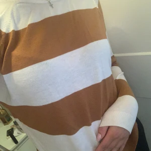 Randig tröja i vitt och brunt - Säljer en superfin randig tröja i vitt och brunt. Den är långärmad och har en normal passform. Perfekt för höst och vår! Tröjan är i bra skick och väldigt bekväm att ha på sig. Passar både till jeans och kjol. 🌟