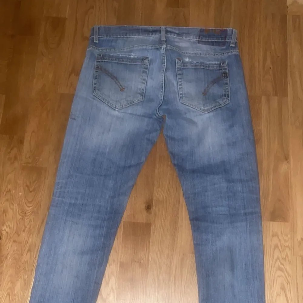 Säljer ett par snygga blå jeans från Dondup i storlek 31. De är i bra skick och har en klassisk femficksdesign. Jeansen har en slim passform och är perfekta för vardagsbruk. De är tillverkade av bomull och har en dragkedja och knapp framtill. . Jeans & Byxor.