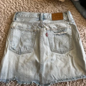 Ljusblå jeanskjol från Levi's - Säljer en snygg ljusblå jeanskjol från Levi's i storlek 24 dvs xs. Använd ett fåtal gånger🩵🩵🩵