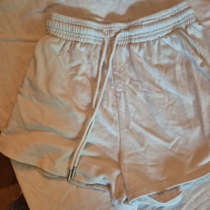 Beige shorts med snörning - Säljer ett par bekväma beige shorts från H&M. De har en elastisk midja med snörning för justerbar passform. Perfekta för sommar och vår, dessa shorts är gjorda av mjukt bomullsmaterial och har en normal passning. De är i välanvänt skick men fortfarande i bra form.