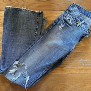 Blå Low Waist Bootcut Jeans - Super snygga bootcut jeans med lågmidja från märket ”7 for all mankind”, som tyvärr är för små. Storlek 24 vilket är storlek 32 EU. Köpte dem begagnat på Vestiaire för 900kr. Pris kan diskuteras och kan skicka fler bilder om det önskas!