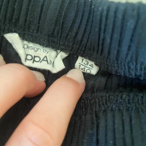 Säljer ett par svarta byxor - Svarta byxor med ett mönster med linjer från Kappahl i storlek 134/140🫶 i bilden se de ut som att de är smutsiga ut pga ljuset där