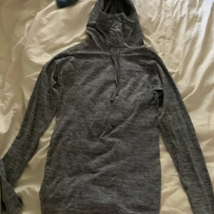 Grå hoodie i nylon och polyester - Säljer en grå hoodie i storlek M. Den är tillverkad av 55% nylon och 45% polyester, vilket gör den både bekväm och hållbar. Perfekt för kyliga dagar eller som ett extra lager under jackan. Hoodien har långa ärmar. Passar bra till både vardag och träning.