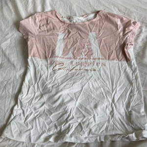 Vit och rosa t-shirt från H&M - Säljer en söt t-shirt från H&M i storlek 146/152. Den är vit med rosa detaljer och har ett tryck på framsidan. T-shirten är kortärmad och gjord av bomull, perfekt för sommaren! Den är i bra skick och redo för en ny ägare. 🌸