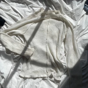 Tröja - Stickad tröja med lite högre krage och som är lite genomskinlig
