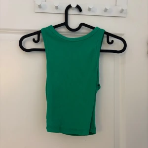 Grön ribbad linnetopp från Zara - Säljer en snygg grön ribbad linnetopp från Zara. Toppen är ärmlös och har en enkel design som passar perfekt till sommaren. Perfekt för att hålla det stilrent och bekvämt.