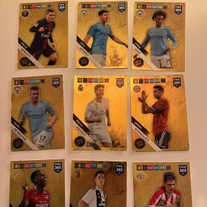 Säljer fotbollskortsamling, ge förslag om pris. - Samling av fotbollskort från FIFA 365 med spelare i olika lagtröjor. Kortens design har en guldig bakgrund med spelarnas bilder och statistik. Perfekt för samlare eller fotbollsfans som vill utöka sin kollektion.