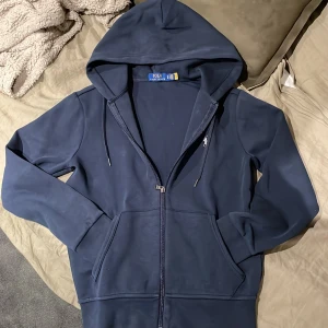 Mörkblå hoodie från Polo Ralph Lauren - Säljer en snygg mörkblå hoodie från Polo Ralph Lauren. Den har använts typ 3 gånger passar S också. Priset kan diskuteras vid snabb affär.  Orginal pris 2300kr. 