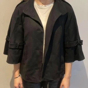 Svart kappa - Snygg svart kappa med trekvartsärm och knappar framtill. Använd sparsamt, skriv för fler bilder eller frågor💕