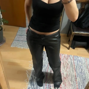 Svarta skinnbyxor - Snygga svarta skinnbyxor med en modern look. De har en rak passform och är perfekta för att ge en edgy touch till din outfit. Passar bra med en enkel topp för en stilren look.