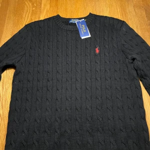 Svart stickad tröja från Polo Ralph Lauren - Säljer en stilren svart stickad tröja från Polo Ralph Lauren med kabelstickat mönster som är helt ny, kom privat för mer frågor 