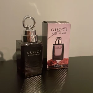 Gucci Pour Homme Eau de Toilette - Säljer en elegant Gucci Pour Homme Eau de Toilette i en stilren mörk glasflaska med silverdetaljer. Flaskan rymmer 100 ml och har en lyxig känsla med sin distinkta design. Perfekt för den som vill ha en sofistikerad doft. Ej använd o h luktar sommar. 10/10