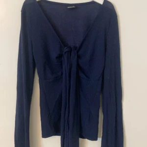 Mörkblå tröja med knyt - Jag säljer en jättefin mörkblå design by si liknande tröja från Gina tricot! Andvänd fåtal gånger. Storlek xs! 