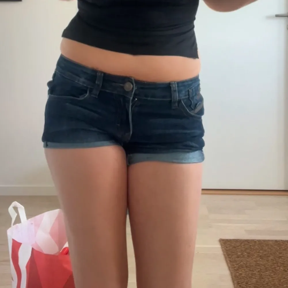 Snygga mörkblå jeansshorts från Dr. Denim. Perfekta för sommardagar med en casual look. De har en klassisk femficksdesign och knappgylf. Passar bra till en avslappnad stil.. Shortsit.