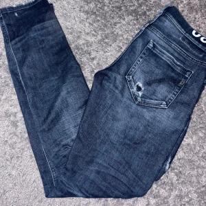 Blåa dondup modell Georage - Säljer ett par mörkblå jeans från Dondup!! Modellen är George, på byxorna är det slitningar som man inte ser huden på förutom på ett ställe!!! Ett hål i röven men man ser inte kallingarna(DET SKA VA DÄR) hör av er vid minsta fundering mvh Charlie 🤝