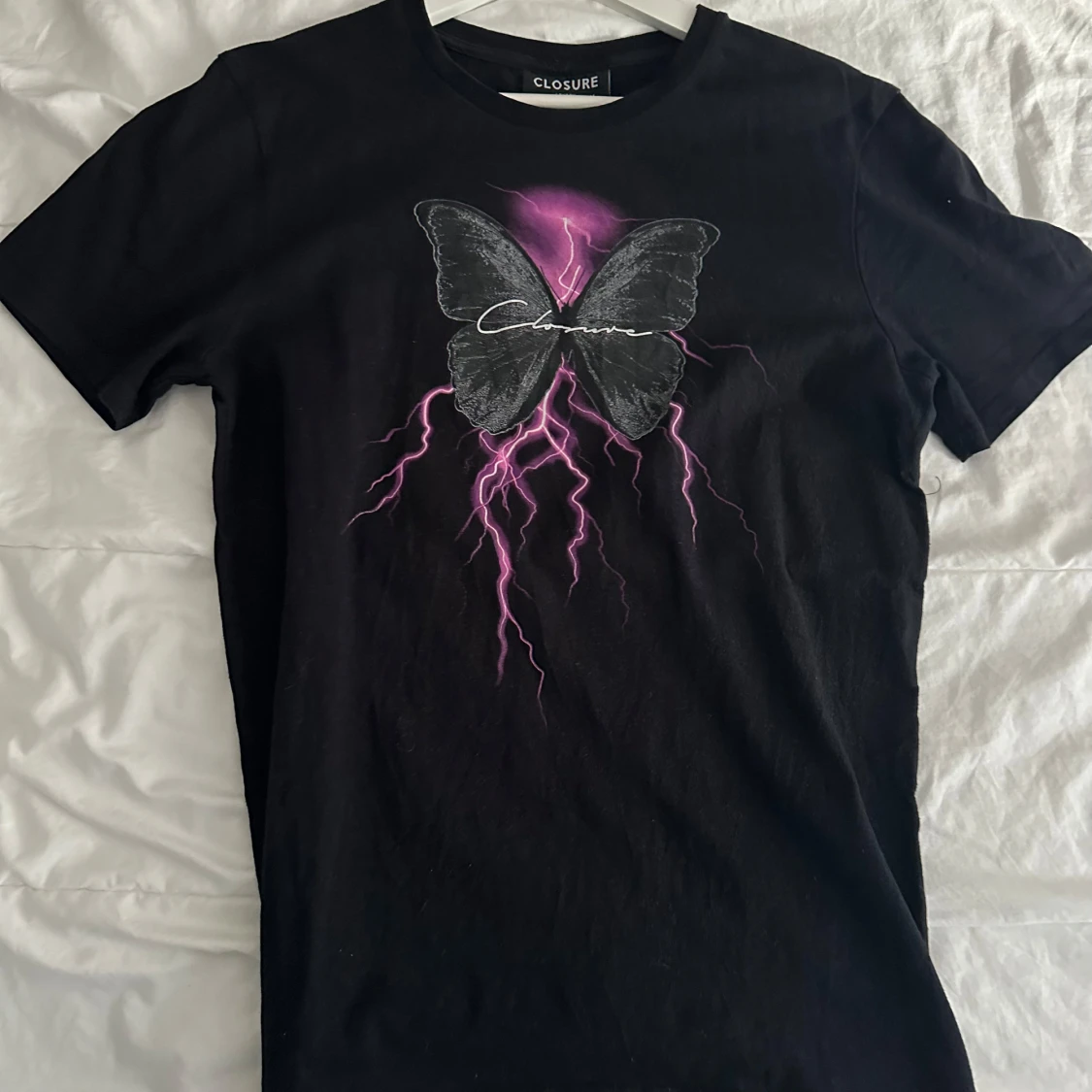 Svart t-shirt med fjärilsmotiv från Closure