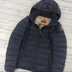 Mörkblå dunjacka från Parajumpers - Välhållens Parajumpers dunjacka,  Storlek: Dam XS, passar för personer som är cirka 160–165 cm långa.  Skick: 9/10, några små fläckar.  Nypris: 480€  Mått: 	•	Längd: 63 cm 	•	Bredd från armhåla till armhåla: 46×2 cm 	•	Bredd från axel till axel: 39 cm 	•	Ärmlängd från axel: 63 cm 	•	Ärmlängd från armhåla: 47 cm 	•	Bredd vid nederkant: 44–48×2 cm