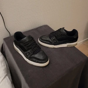 Svarta sneakers med monogramdetaljer - Lv trainers designade av virgil abloh.  perfekt för en trendig look. Självklart äkta!Dustbag följer med på köpet, kom privat för fler bilder🤝 (små skador vid framsida där av priset)