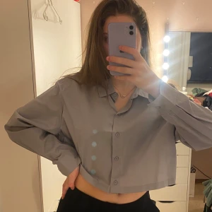 Grå croppad skjorta - Grå croppad skjorta med knappar framtill. Från h&m.