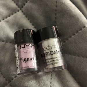 Pigment från NYX och Technic - Två burkar med löst pigment. NYX erbjuder en ljusrosa nyans medan Technic har en skimrande vit färg. Perfekt för att skapa intensiva ögonmakeup-looks.