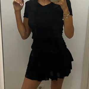 Svart klänning från Maje - ‼️SKRIV INNAN DU KÖPER, SÅ LÖSER VI FRAKTEN EFTERSOM ATT JAG ÄR I SPANIEN‼️   Snygg svart klänning från Maje med korta ärmar och v-ringning. Den har en snygg passform med detalj i midjan och en lätt volang nedtill. Perfekt för en riktigt snygg look.