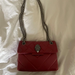 Kurt geiger väska - En superfin röd Kurt geiger väska som är köpt för 2 195kr men säljer för 1000kr 💞 passar perfekt nu till hösten och är i superbra skick bortsett från lite sliten vid hörnen på väskan vilket man inte ser, kom privat för fler bilder, frågor osv 💓