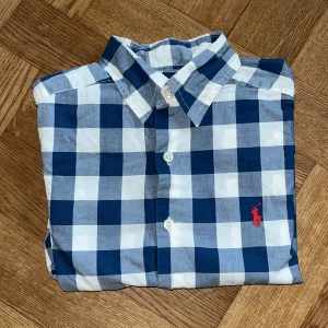 Ralph Lauren Skjorta - Hej! Jag säljer nu denna Ralph Lauren skjortan! Den är i ganska bra skick och har används några gånger, den är i storlek 8y men nog passar upp till 10y. Skicka DM om du har några frågor eller vill ha fler bilder! 😀