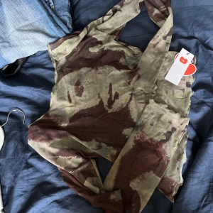 Mesh grön och brun tröja - Funkar offshoulder eller boatneck. Nyskick med original tag kvar. Strechig. Coolt tryck