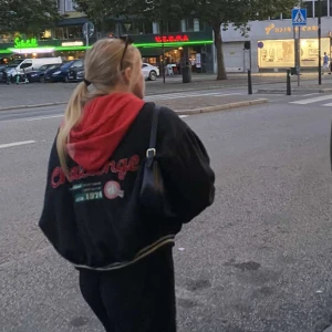 Svart bomberjacka från Dobber - Säljer en snygg och cool svart bomberjacka från Dobber med texten 'Challenge' broderad på ryggen. Jackan har vita och svarta ribbade muddar vid ärmslut, krage och nederkant. Perfekt för höst och vår! 🖤