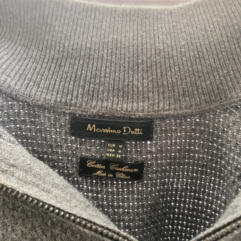 Säljer en stilren grå tröja från Massimo Dutti i storlek M. Tröjan är tillverkad i en mjuk kashmirblandning och har en dragkedja framtill. Den har långa ärmar och ribbade muddar, vilket gör den perfekt för både höst och vinter. Passar både till vardags och lite finare tillfällen.. Tröjor & Koftor.