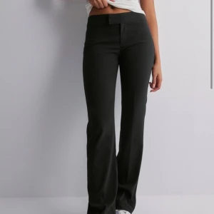 Low waist suit pant nelly  - Säljer dessa lågmidjade kostymbyxorna i bra skick i storlek 38, men säljer de då de är lite liten i storlek, så de passar ej mig helt som vanligtvis har 38.