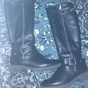 Svarta Stövlar - LÄS BIO! De är strl 37, lite stora om du har strl 36, kommer vara tighta i tårna om du har strl 38 osv. Dragkedjan innåt funkar och de utåt är för design, jag har själv aldrig använt dem pga för små men köpte de second hand. Priset kan diskuteras ❤️