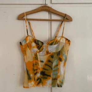 mönstrad korsett-topp plt - supersöt mönstrad korsett topp från prettylittlething med dragkedja i ryggen! har lite lösa trådar här och har, samt spännet i ryggen har lossnat, se bilder.