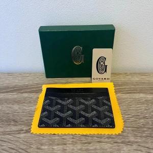 Goyard plånbok - Säljer en svart goyard plånbok 🐼. Den har aldrig använts och kommer med box, tag, duk. Super bra kvalite och super snygg. Har man några frågor eller vill ha mer bilder är det bara att höra av sig. 👍