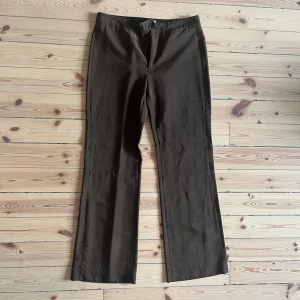 Bruna byxor från Filippa K - Säljer ett par snygga bruna byxor från Filippa K. De har en klassisk stil med en rak passform och är perfekta för både vardag och fest. Ej true to size, skulle säg att de passar 38-40. Glansigt ostretchigt material. Använd 1 gång